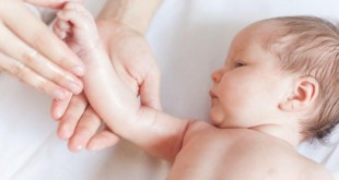Mama dando un masaje a su bebe con piel atópica